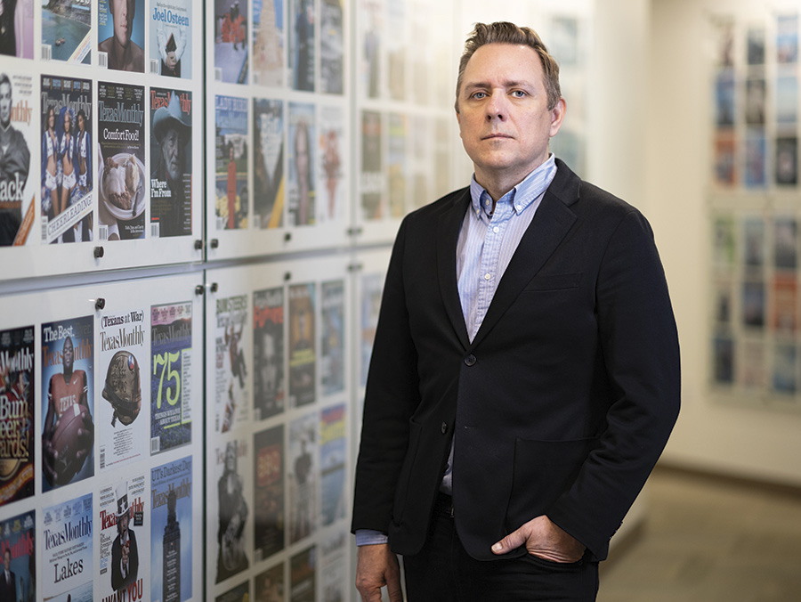 Ross McCammon standing beside covers of Texas Monthly past issues