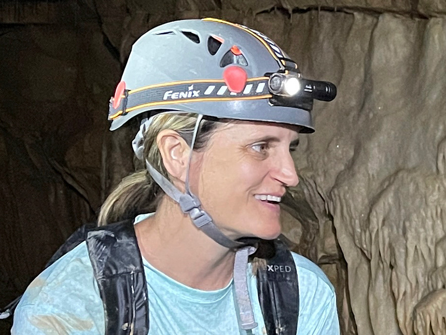 Erika Jaeggli in a cave wearing a lighted mining hardhat