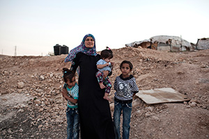 UNT alumna Tanya Habjouqa ('02) on assignment with Bedouin, an Arabic ethnic group who are in danger of being forcibly relocated outside Jerusalem. She is pictured with her daughter, who was just under a year. Since she had been photographing in the community all day, a teen girl insisted on taking a portrait of her with Habjouqa dressed in a hijab and coat and her daughter.