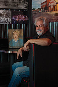 Eddie Wilson with a portrait of young Stan Alexander, at Threadgill's in Austin (Photo by Ahna Hubnik)