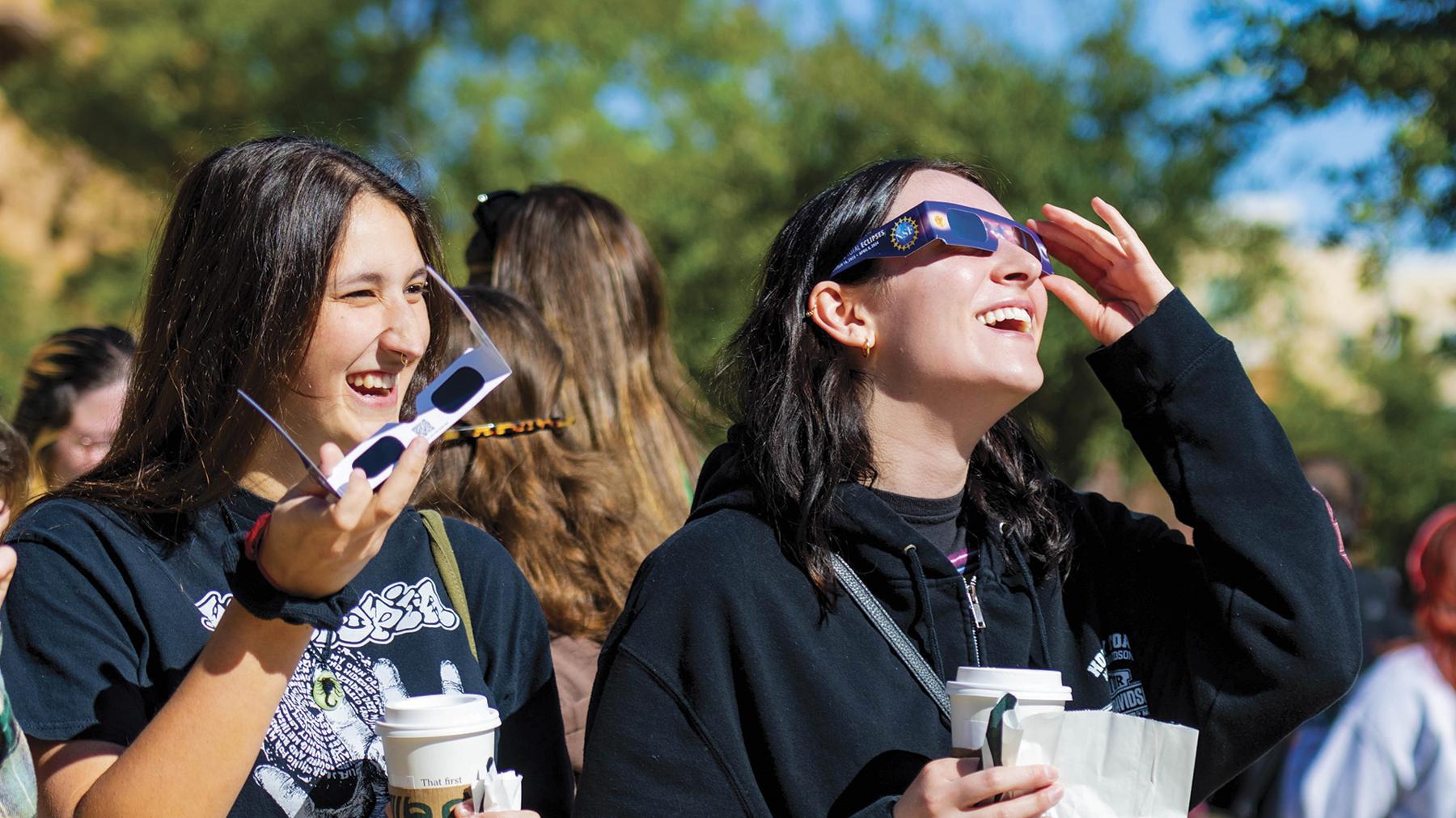 Students with specialized glasses view and eclipse