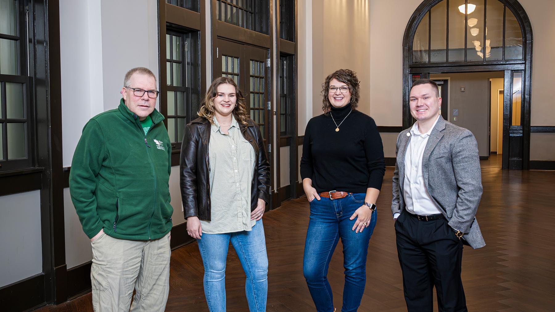 Carl Parsons, Shelby Simmons Haney ('23), Neely Shirey ('09) and Kirk Plum ('18, '18 M.S.) pose in the historic Curry Hall corridor.