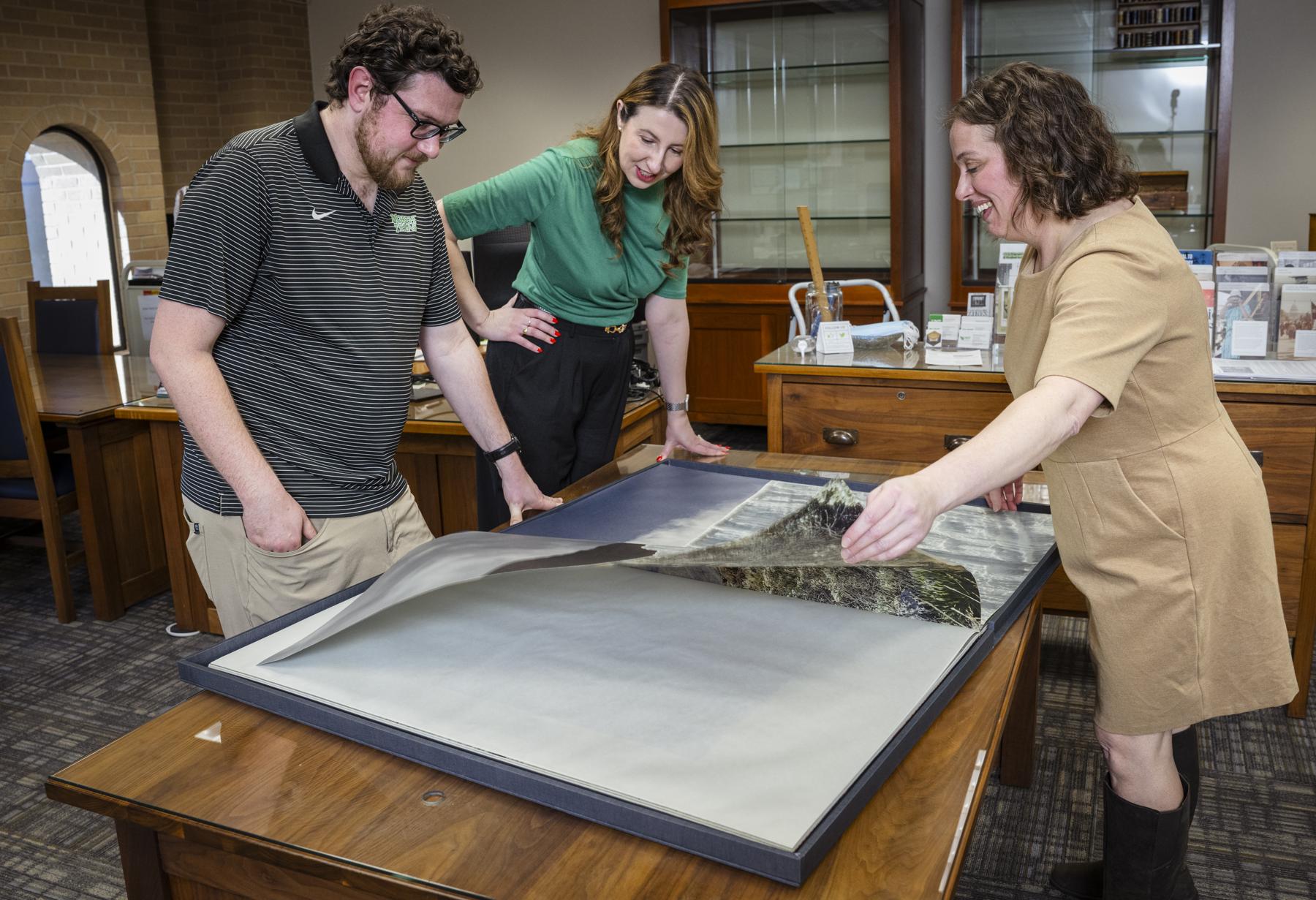 Photo of UNT faculty and staff examining document in the Special Collections room