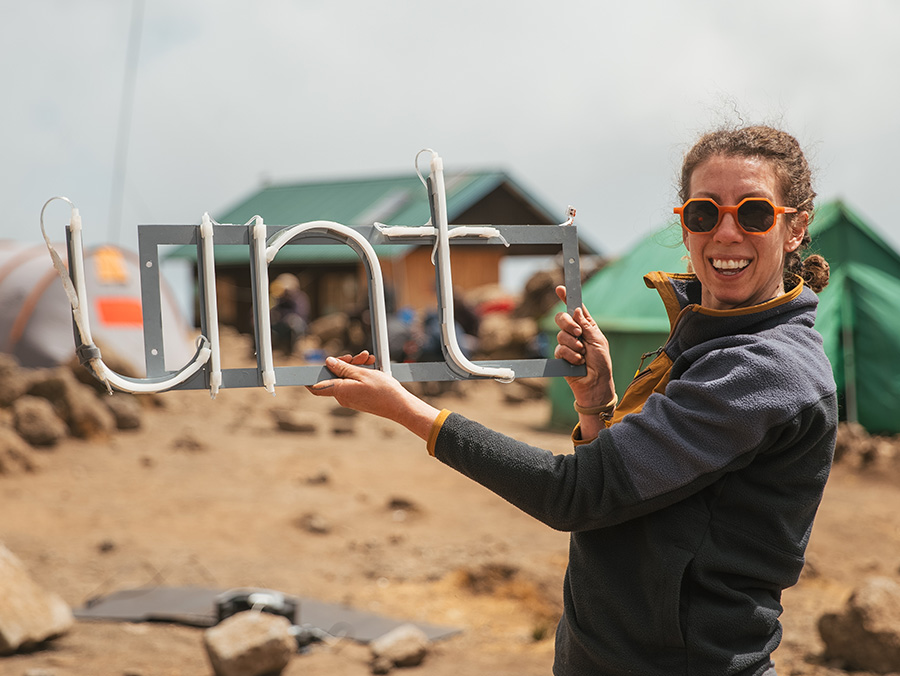 Alicia Eggert with a portion of the sculpture that contains the letters, U, N, T
